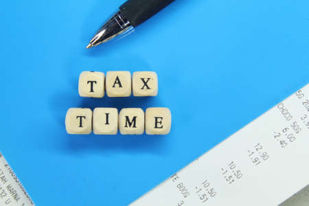 receipts, pens, wooden cubes with the word Tax Timeの写真素材