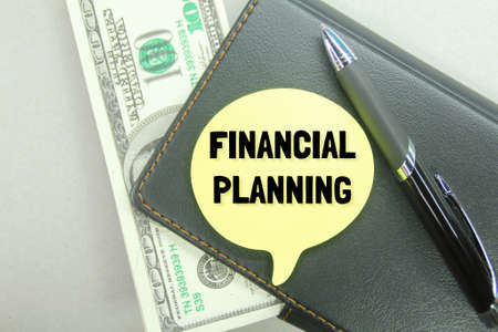 notebooks, pens, banknotes with the words FINANCIAL PLANNINGの写真素材