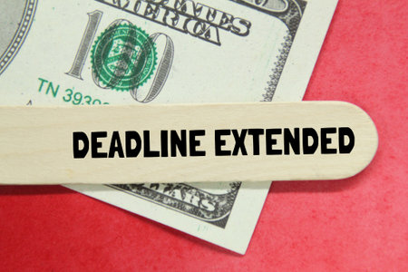 banknotes, a piece of board with the word DEADLINE EXTENDEDの写真素材