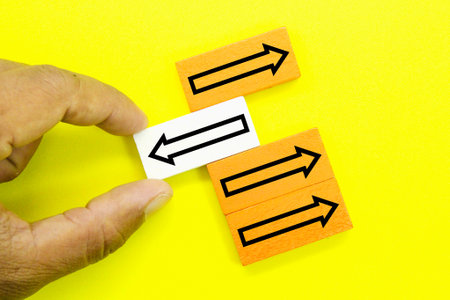 the hand picks the arrow facing in the opposite direction. Different thinking, individualityの写真素材