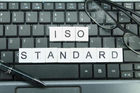 laptop keyboard, glasses, blue compartment with the word ISO Standardの写真素材