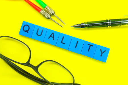 arrows, glasses, pens and quality words on the blue squaresの写真素材