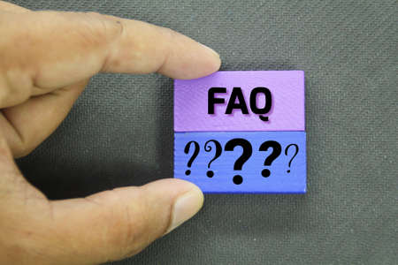 hand holding a colored board with question marks and FAQ or answers aboveの写真素材