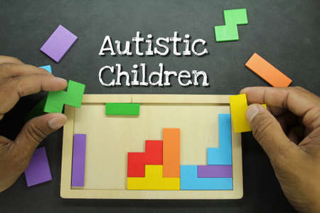 hand composing puzzle with the word autistic childrenの写真素材
