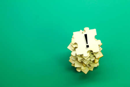 wooden puzzles and Exclamation marks on a green background with copy space.の写真素材