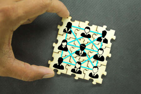 Puzzles with icons of a group of team workers. the concept of group relationshipsの写真素材