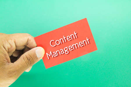 hand holding a red card with the word content managementの写真素材