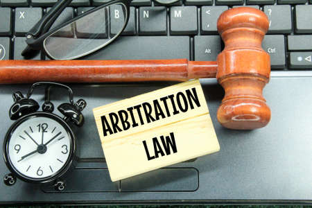 glasses, hammers, alarm clocks and wooden boards with the words arbitration lawの写真素材