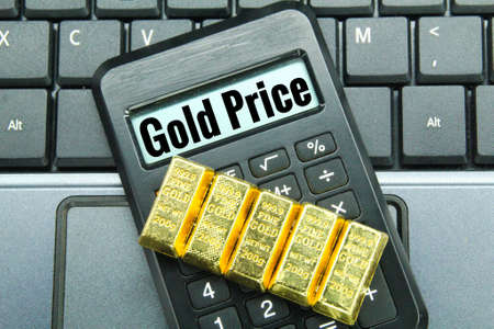 gold and a calculator with the word gold price. the concept of the value of gold