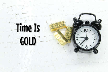 gold ingots and alarm clocks with the words time is goldの写真素材