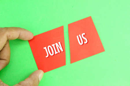 hand holding a red paper cut with the words join us
