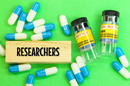 medicine bottles, pills and wooden boards in the words of researchers