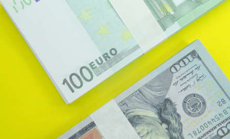 euro and dollar banknotes with a yellow background. financial conceptsの写真素材