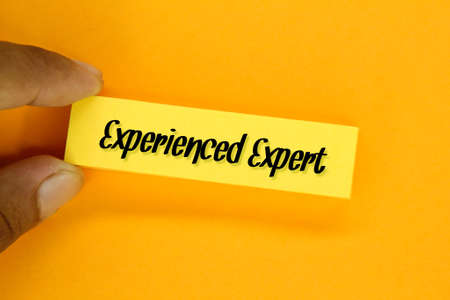 fingers holding colored paper with the word experienced expertの写真素材