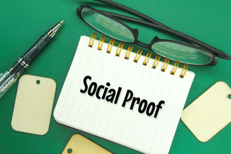 glasses, pens and notebooks with the word social proofの写真素材
