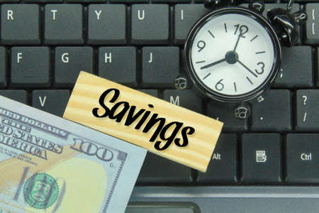 alarm clocks, banknotes, laptop keyboards and wooden boards with the word savings