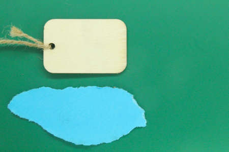 Torn paper and blank wooden tags with space for text with a dark backgroundの写真素材