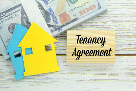 paper houses, paper money and wooden boards with the words tenancy agreementの写真素材