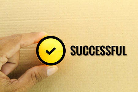 hand holding the ball with the success icon and the word successfulの写真素材