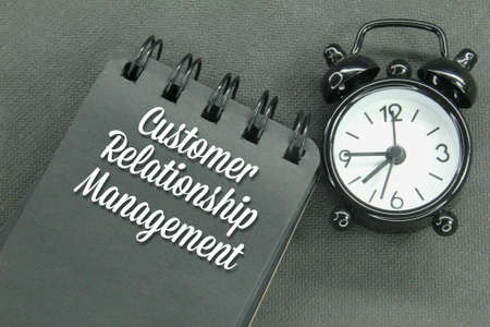 alarm clocks and notebooks with the letters CRM or the words Customer Relationship Management