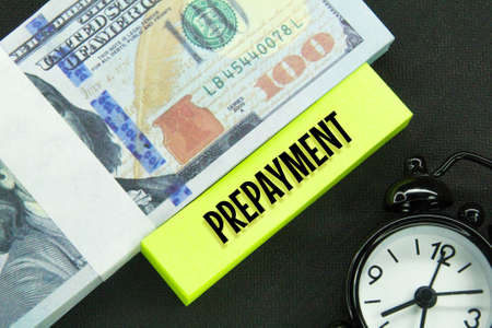 banknotes, alarm clocks and colored paper with the word prepaymentの写真素材