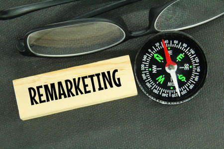compasses, glasses and wooden boards with the word remarketingの写真素材