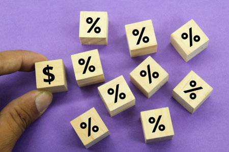 wooden cubes strewn with percentage icons and money icons are taken. the concept of taking advantageの写真素材