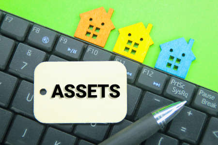 laptop keyboards, pens and wooden tags with the words Asset or property ownerの写真素材