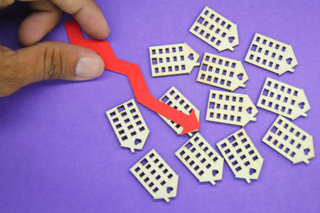 house and down arrow. the concept of price or home value plummeting. home values fallの写真素材