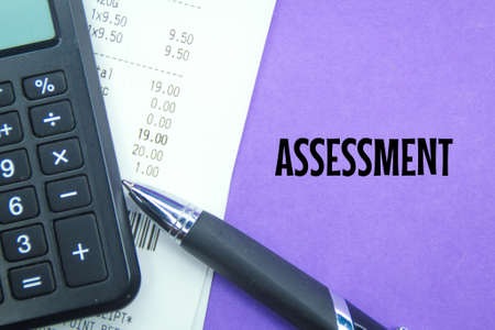 calculator, receipt and pen with the word assessmentの写真素材