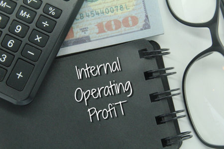 banknotes, glasses, calculators and notebooks with the words internal operating profit