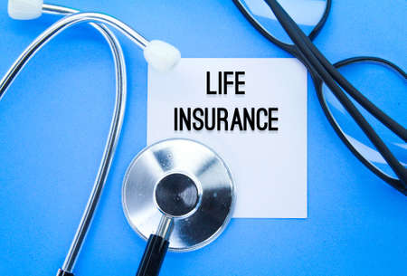 stethoscope, glasses and white paper with the word life insurance. the concept of health insurance