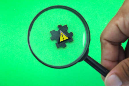 the magnifying glass looks for a sign of caution. the concept of a careful signの写真素材
