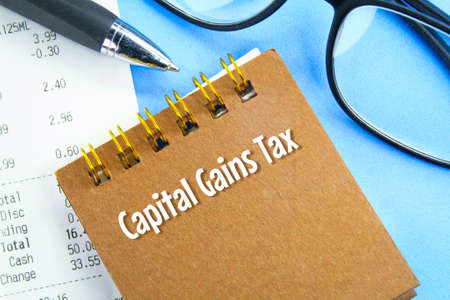 pens, receipts, glasses and notebooks with the words Capital Gains Taxの写真素材