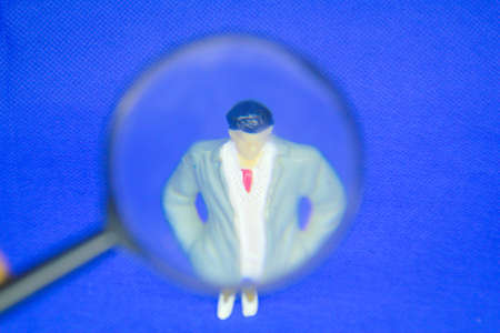 a magnifying glass looking for a leader or a man with a blurred backgroundの写真素材