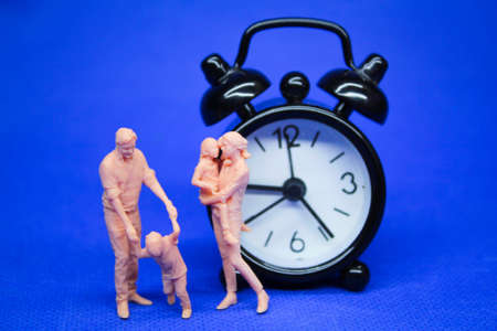 Quality time with a family concept. miniature people and clockwork bells concept of family time. Selective focusの写真素材