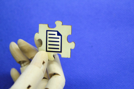 hand holding wooden puzzle with file iconの写真素材