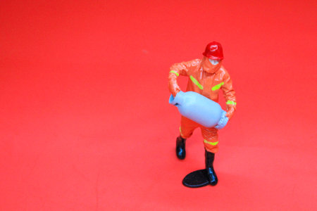 model firefighter carrying fire gas by showing how to properly close the gas tank valve. Selective focusの写真素材