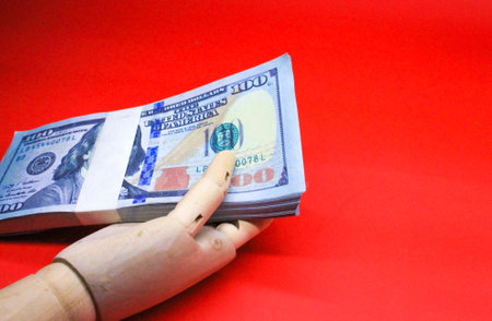 wooden hand holding a dollar bill. US banknote. Business conceptの写真素材
