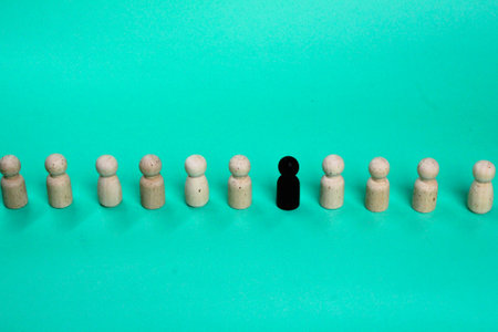 a row of wooden figures and a strange one. unique or different conceptsの写真素材