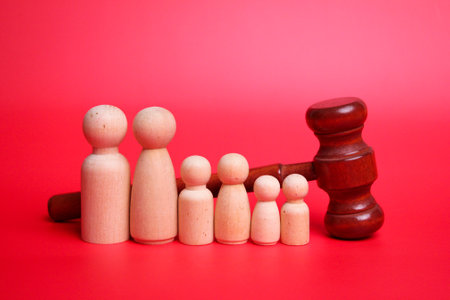 Family law concept. Judge gavel with many wooden figures of family members close-up.の写真素材