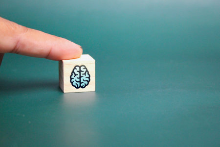 finger pressing wooden cube with brain icon. innovation concept