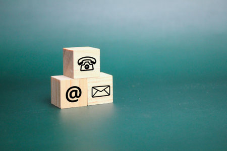 three wooden cubes with contact icons. conceptual of communication and business support.の写真素材