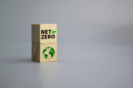 wooden cube with earth icon and word NET ZERO. The natural environment is a carbon neutral and net zero concept. Net Zero Emissions Goals Weather neutral long-term strategy.の写真素材