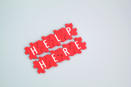 red puzzle with the word help here. the concept of giving help or help here. Business and get help here concept.の写真素材