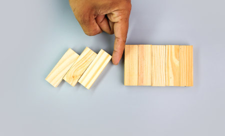 fingers keep the wood from falling from a stable place. the concept of risk. take a risk. business risk, stability, fall, risk, collapse.の写真素材