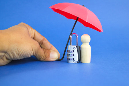 hands provide protection with keys and wooden figures. the concept of personal privacy protection. personally identifiable information. Personal Safety Protectionの写真素材