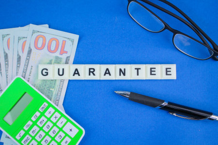 calculator, paper money and pen with the word guarantee. the concept of guarantee and warrantyの写真素材