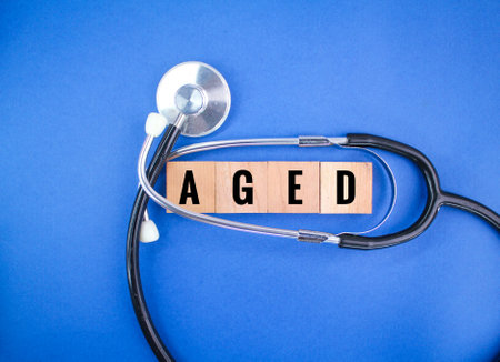 stethoscope and wooden square with the word aged. the concept of getting old or agingの写真素材