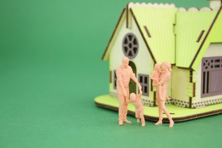 miniature family with the background of the house and car they own. new family home. family home conceptの写真素材